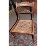 Set of four Regency simulated rosewood, cane seated and sabre leg dining chairs with carved and