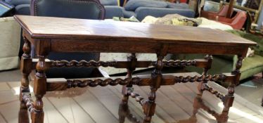 Early 20th century oak stool of rectangular form with planked top over twisted stretchers, 130cm