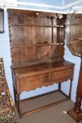 Small 20th century oak dresser, the boarded back with two shelves, the base with two drawers and