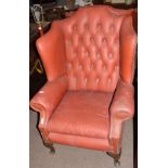 Pair of early 20th century red leatherette covered wing armchairs with button back and supported