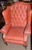 Pair of early 20th century red leatherette covered wing armchairs with button back and supported