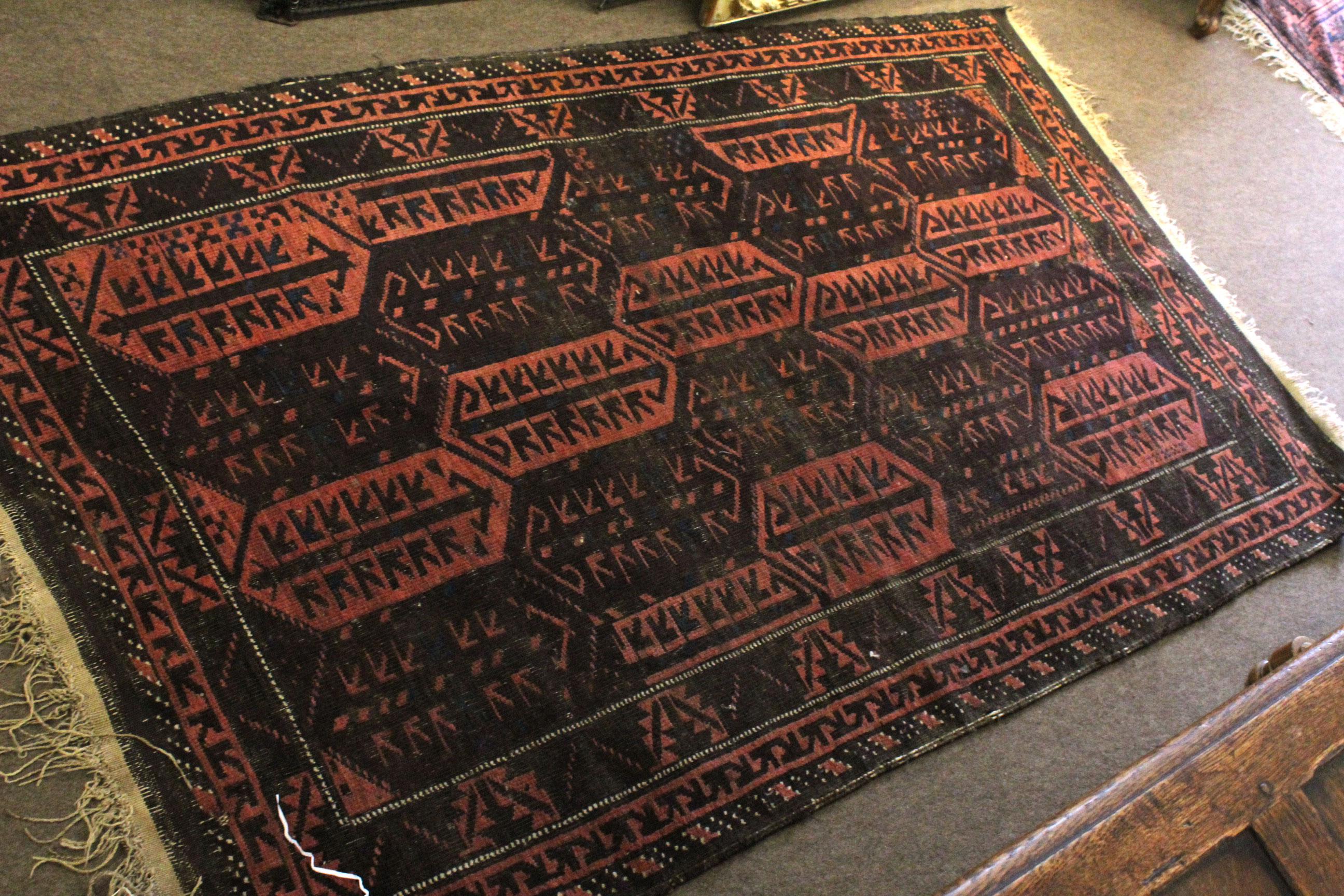 Early/mid 20th century Bokhara type wool rug with repeating geometric patterns in black to a red