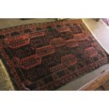 Early/mid 20th century Bokhara type wool rug with repeating geometric patterns in black to a red