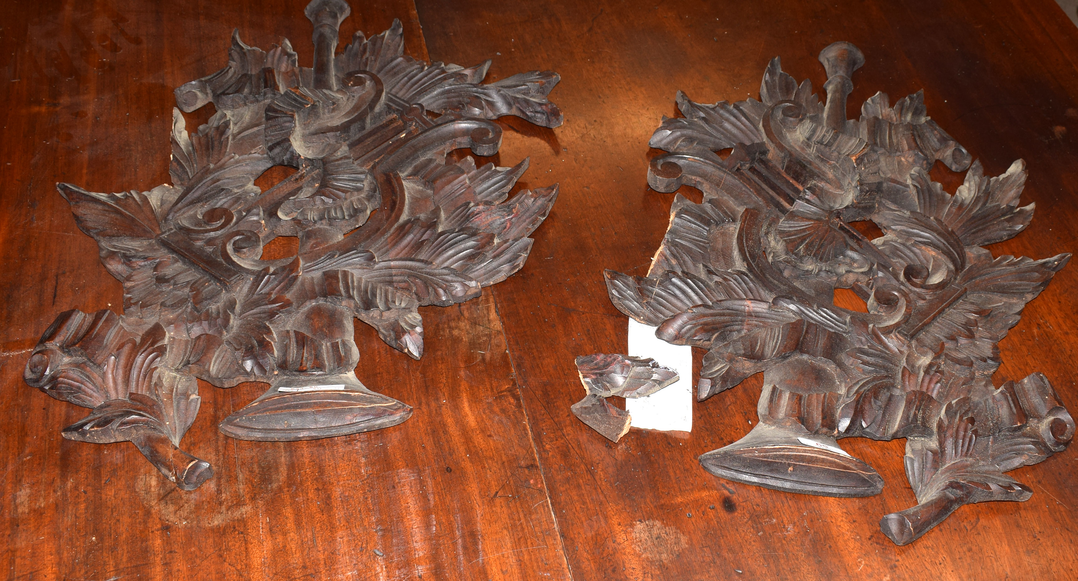 Interesting pair of carved and pierced stained softwood wall hangings in classical style featuring a