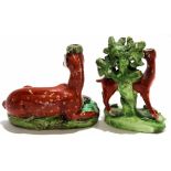 Pair of Staffordshire models of deer, one leaning against bocage, the other recumbent, (2)