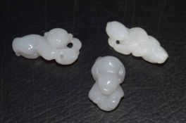 Group of three small white jade carved figures of boys, probably intended as netsuke (3)