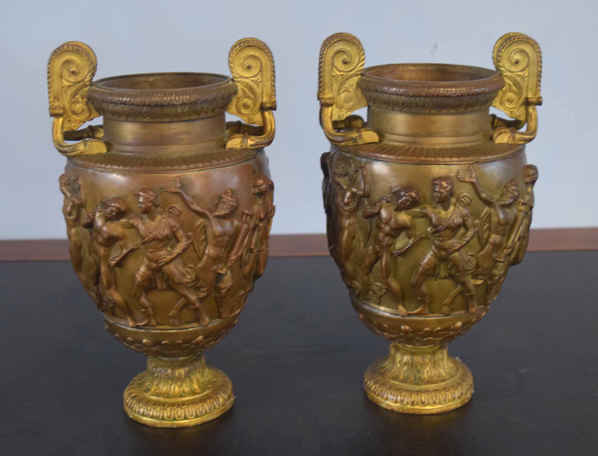 Pair of parcel gilded bronze patinated two-handled vases, bodies each embossed with classical