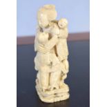 Ivory Okimono, Meiji period, of a lady with two children seated on a chair, 10cm high