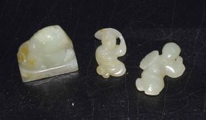 Group of three green jade pieces including a seal with a mythical beast carving, and two small