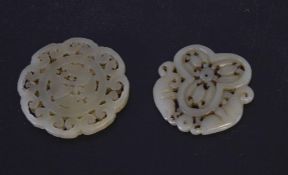 Two jade medallions with carving, one with fish, one with geometric designs (2)