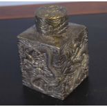 White metal caddy and cover of square section decorated with dragons in relief, the cover with