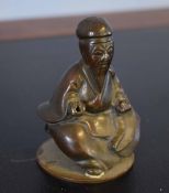 Oriental metal ware model of a sage on a circular base