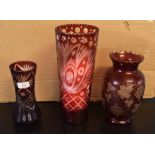 Two Bohemian style vases, one with a cut glass design on puce ground, the other with a leaf and