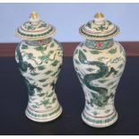 Pair of Oriental porcelain vases decorated in a famille vert palette with dragons amongst clouds,