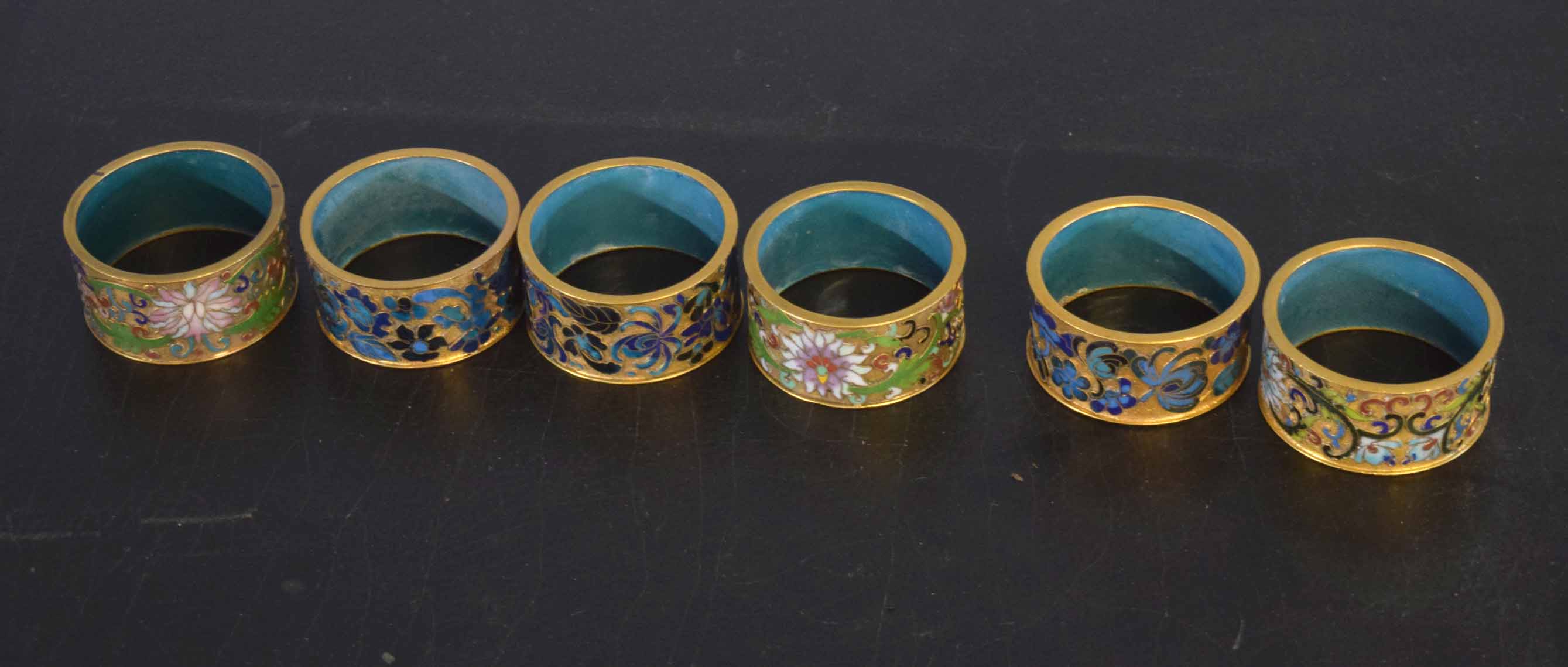 Collection of six champleve enamel decorated napkin rings