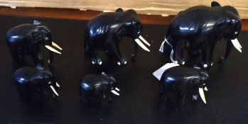 Group of six ebony wooden elephants with bone/ivory tusks