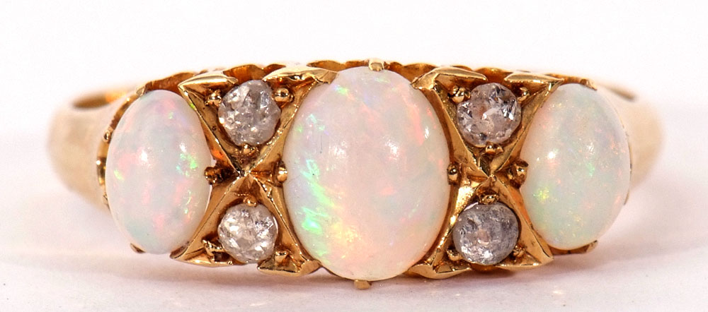 Opal and diamond ring featuring three graduated oval cut cabochon opals, highlighted with four small