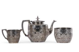 Victorian three-piece tea set in Indian taste, of circular form, highly chased and embossed with