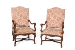 Pair of European walnut high back armchairs, slightly splayed arms terminating in scroll moulded