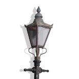 Victorian cast metal street lamp with a four glass tapering metal framed shade resting on a black