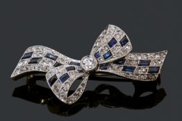 Sapphire and diamond tied bow brooch, featuring a central old cut diamond, millegrained set, the