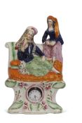 Staffordshire pottery clock holder figure with two Middle Eastern figures seated in repose above a