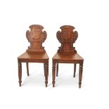 Pair of early 19th century mahogany hall chairs in the Irish manner, the short backs with