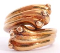 A large "750" stamped crossover ring, a stylised thread and bead design, size M/N, 14.8gms