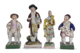 Group of English pottery figures including a gentleman and lady seated in chairs on green