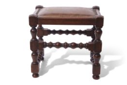 Early 20th century teak jointed stool with bobbin turned supports and stretchers, having rexine