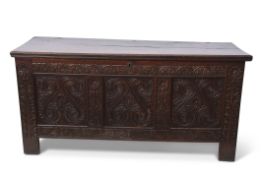 18th century oak coffer, plain top and three panelled carved front, decorated with scrolls etc on