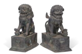 Pair of large spelter or alloy studies of seated temple dogs, one with a ball under its right