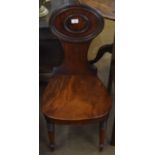 Early 19th century mahogany hall chair, oval moulded back, solid seat and bowed apron raised on ring
