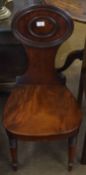 Early 19th century mahogany hall chair, oval moulded back, solid seat and bowed apron raised on ring