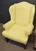 Georgian style mahogany wing back armchair upholstered in patterned yellow