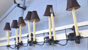 Set of four modern wrought iron two-branch wall sconces, black anodised throughout in the Gothic