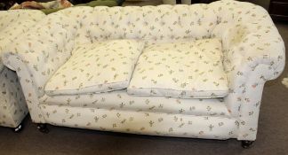 Matched pair of late Victorian Chesterfield sofas both upholstered in matching floral button back (