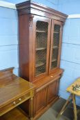 Victorian mahogany bookcase cabinet, two arched panelled doors with gilt metal grilles enclosing