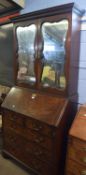 Mahogany bureau cabinet, the top with two mirror doors enclosing an interior with adjustable