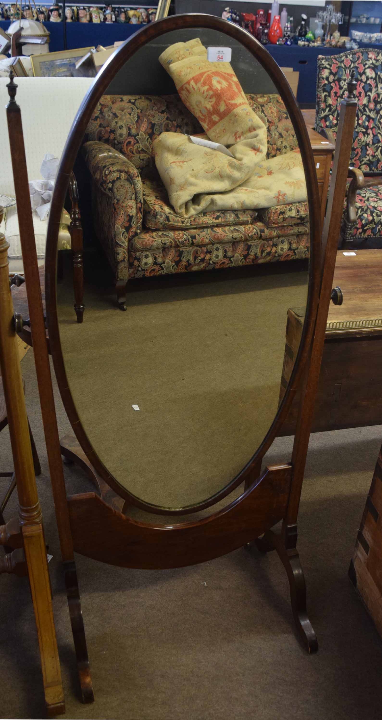 Mahogany cheval mirror, oval mirror back crested with brass urn finials raised on splayed swept