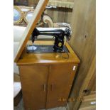 SMALL 1950S SEWING MACHINE CABINET CONTAINING A SINGER SEWING MACHINE SERIAL NO EE533567, CABINET