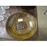 ART POTTERY SLIP WARE DISH WITH A PORTCULLIS DESIGN TO CENTRE IN TONES OF BROWN SLIP, JS MONOGRAM TO