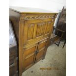 MID-20TH CENTURY CARVED HEAVY OAK REPRODUCTION COCKTAIL CABINET WITH LINENFOLD AND OTHER PANELLED