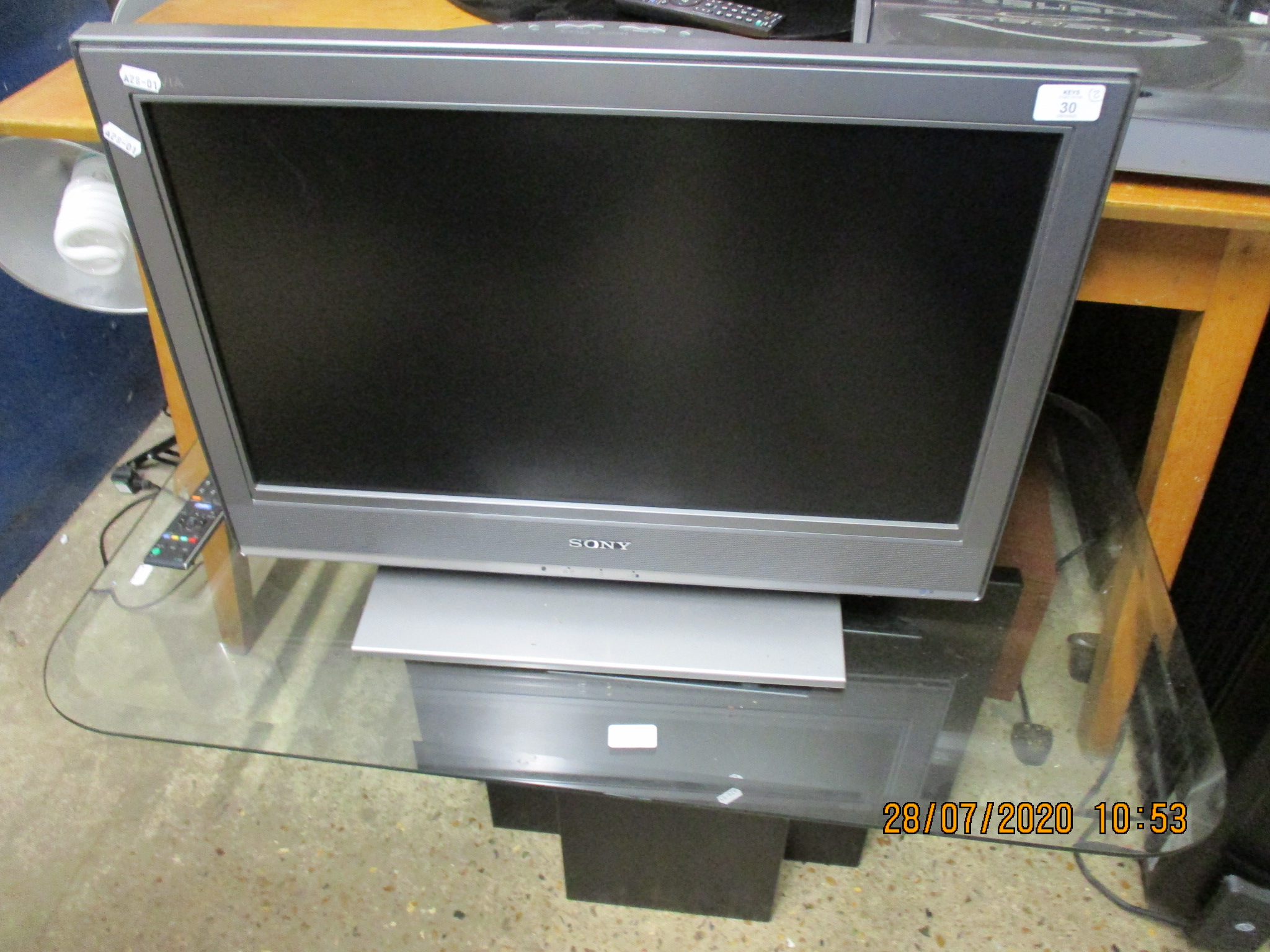 SONY 26” FLAT SCREEN TV TOGETHER WITH GLASS TOPPED STAND