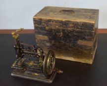 Early cast iron small sewing machine in an ebonised pine box, possibly Powell or Willcox & Gibbs,