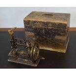 Early cast iron small sewing machine in an ebonised pine box, possibly Powell or Willcox & Gibbs,