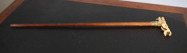 Malacca cane applied with a bone or ivorine handle formed as a temple dog with a ball in its