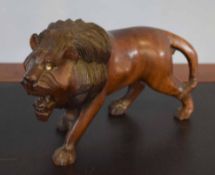 Cast hardwood model of a standing lion, 17cm high