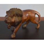 Cast hardwood model of a standing lion, 17cm high