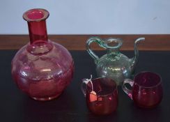 Group of four glass wares including a globular ruby decanter, two small cups and a further green